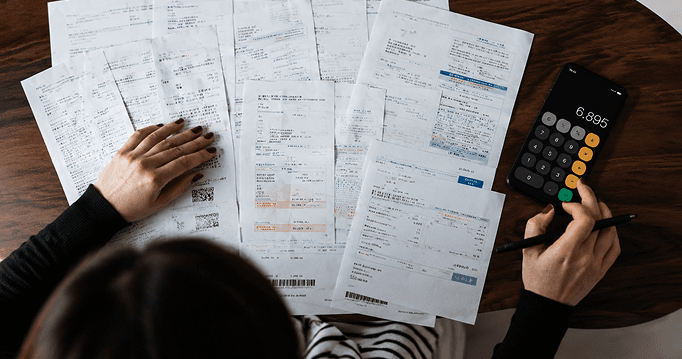 Hands sorting invoices and receipts on a desk
